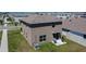 Aerial view of a two-story home with a well-maintained lawn, small patio, and grilling area in the backyard at 16894 Delia St, Wimauma, FL 33598