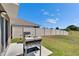 An outdoor grill sits on a patio, offering a great spot for cooking in this well-maintained backyard with a vinyl fence at 16894 Delia St, Wimauma, FL 33598