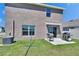 A cozy backyard with sliding glass doors, a small patio, and two grills, perfect for outdoor cooking and entertaining at 16894 Delia St, Wimauma, FL 33598