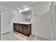 Bathroom with double sinks, dark cabinets, neutral walls, and a shower and tub combo at 16894 Delia St, Wimauma, FL 33598