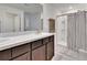 Bathroom with double sinks, dark cabinets, neutral walls, and a shower and tub combo at 16894 Delia St, Wimauma, FL 33598
