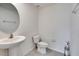 Modern half bathroom with a stylish pedestal sink, tiled flooring, and neutral decor at 16894 Delia St, Wimauma, FL 33598