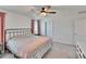 Comfortable bedroom with a ceiling fan, neutral carpet, and bright windows with pink curtains at 16894 Delia St, Wimauma, FL 33598