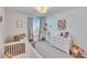 Charming Bedroom showcasing a crib, chair, and dresser with decor at 16894 Delia St, Wimauma, FL 33598