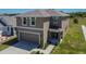 Charming two-story home featuring a two-car garage, landscaped front yard, and inviting entryway for a welcoming appeal at 16894 Delia St, Wimauma, FL 33598