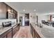 Open concept kitchen featuring stainless steel appliances, dark cabinetry, and an island with granite countertops at 16894 Delia St, Wimauma, FL 33598