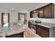 Modern kitchen features granite countertops, dark cabinetry, and stainless steel appliances at 16894 Delia St, Wimauma, FL 33598