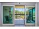 Balcony view with seating through sliding glass doors overlooking serene greenery and nature at 1806 Mariner Dr # 112, Tarpon Springs, FL 34689