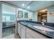 Bathroom features dual sinks with granite countertops, white cabinets, and tile floors for an elegant touch at 1806 Mariner Dr # 112, Tarpon Springs, FL 34689