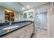 Bathroom features dual sinks, granite countertops, walk-in shower, and tiled floors for a spa-like experience at 1806 Mariner Dr # 112, Tarpon Springs, FL 34689