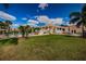 Beautiful clubhouse exterior with well-manicured lawn and palm trees, perfect for outdoor relaxation and gatherings at 1806 Mariner Dr # 112, Tarpon Springs, FL 34689