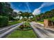 Entry to the community with mature trees and colorful tropical landscaping at 1806 Mariner Dr # 112, Tarpon Springs, FL 34689