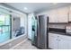 Bright kitchen featuring stainless steel refrigerator, white cabinets, and balcony access at 1806 Mariner Dr # 112, Tarpon Springs, FL 34689
