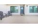 Outdoor patio area with two chairs, neutral flooring, and a view into the home through the sliding glass entry door at 1806 Mariner Dr # 112, Tarpon Springs, FL 34689