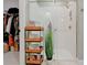 Modern bathroom featuring a glass-enclosed shower, white tiles, and storage cart at 19475 Bristol Wood Pl, Brooksville, FL 34601