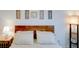 Serene bedroom with wood headboard, soft bedding, and decorative floral wall art at 19475 Bristol Wood Pl, Brooksville, FL 34601