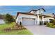 Charming single-Gathering home with a brick driveway, a gray garage door, and manicured landscaping at 19475 Bristol Wood Pl, Brooksville, FL 34601