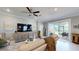 Cozy living room featuring a large sectional sofa, ceiling fan, and sliding glass doors to lanai at 19475 Bristol Wood Pl, Brooksville, FL 34601