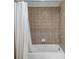 Close-up of the tiled shower and tub featuring a white curtain at 20113 Bending Creek Pl, Tampa, FL 33647