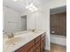 Bathroom featuring double sinks, granite countertops, wood cabinets, and a tiled shower and tub at 20113 Bending Creek Pl, Tampa, FL 33647