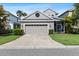 Charming single-Gathering home featuring a two-car garage, well-manicured landscaping, and neutral paint at 20113 Bending Creek Pl, Tampa, FL 33647