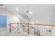 Bright loft featuring vaulted ceilings, wood railing, carpet floors, and large windows for natural light at 20113 Bending Creek Pl, Tampa, FL 33647