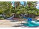 Community pool featuring a water slide, surrounded by lush tropical landscaping at 20113 Bending Creek Pl, Tampa, FL 33647