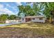 A cozy home with a spacious yard and a new driveway, all surrounded by mature trees at 2106 W Saint Isabel St, Tampa, FL 33607