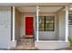 Inviting front porch with a red door, decorative pillars, and tile flooring detail at 2106 W Saint Isabel St, Tampa, FL 33607