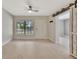 Bright living room featuring wood-look tile flooring, a barn door, and a modern ceiling fan at 2106 W Saint Isabel St, Tampa, FL 33607