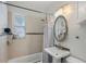 Bright bathroom with a shower-tub combo, tiled walls, and a pedestal sink, offering a clean design at 249 41St Ne Ave, St Petersburg, FL 33703