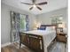 Cozy bedroom with a queen-sized bed, stylish curtains, ceiling fan, and wood-look flooring at 249 41St Ne Ave, St Petersburg, FL 33703
