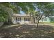 Quaint single-story house with dark shutters, a well-kept lawn, and mature trees, showcasing its curb appeal at 249 41St Ne Ave, St Petersburg, FL 33703