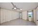 Bright bedroom with light gray tile flooring, ceiling fan, windows, and closet space at 2509 Locksley St # 237, Sun City Center, FL 33573