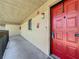 Bright red front door with a modern electronic doorbell and wall-mounted light fixture at 2693 Sabal Springs Cir # 206, Clearwater, FL 33761