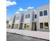 Modern townhome exteriors with white fence, contrasting trim, and expansive dark framed windows at 2810 N Florida Ave, Tampa, FL 33602