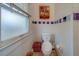 Cozy bathroom featuring a toilet, window, and wall cabinet for storage at 2835 Dartmouth N Ave, St Petersburg, FL 33713