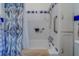 Bathroom including tub with blue patterned shower curtain and white tiled walls at 2835 Dartmouth N Ave, St Petersburg, FL 33713