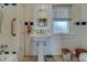 Bathroom featuring a white pedestal sink, mirror, and tiled walls and floors at 2835 Dartmouth N Ave, St Petersburg, FL 33713