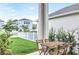 Outdoor patio with dining set, green lawn, white picket fence, and lush landscaping, providing a serene space at 28680 Cozy Creek Dr, Wesley Chapel, FL 33543