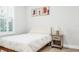 Cozy bedroom with a simple bed, wooden nightstand, modern art and shuttered window, creating a minimalist space at 28680 Cozy Creek Dr, Wesley Chapel, FL 33543