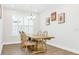 Dining room featuring a wooden table with seating for four and a large window with plantation shutters at 28680 Cozy Creek Dr, Wesley Chapel, FL 33543