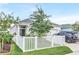 Beautiful home showcasing a well-maintained lawn, white picket fence, and a sleek black SUV parked in the driveway at 28680 Cozy Creek Dr, Wesley Chapel, FL 33543