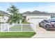 Charming single-Gathering home with a well-manicured lawn, white picket fence, and a private driveway at 28680 Cozy Creek Dr, Wesley Chapel, FL 33543