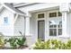 Inviting entrance of a charming white home with beautiful landscaping and stone accents at 28680 Cozy Creek Dr, Wesley Chapel, FL 33543
