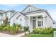 Charming two-story home with a landscaped yard, and covered porch on a sunny day at 28680 Cozy Creek Dr, Wesley Chapel, FL 33543