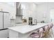 Well-lit kitchen featuring a large island, barstool seating, white cabinets, and stainless steel appliances at 28680 Cozy Creek Dr, Wesley Chapel, FL 33543