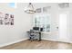 Bright home office features a modern desk setup, a large window, and neutral decor with beautiful tile flooring at 28680 Cozy Creek Dr, Wesley Chapel, FL 33543