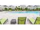 Inviting community pool surrounded by lounge chairs, greenery, and neighborhood homes in the background at 28680 Cozy Creek Dr, Wesley Chapel, FL 33543