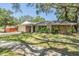 Charming home featuring stone accents, a well-manicured lawn and beautiful trees at 34 Hickory Ln, Safety Harbor, FL 34695